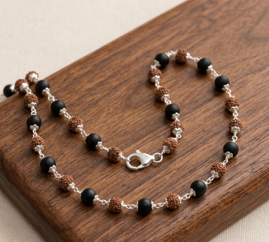 Image of karungali and rudraksha mala made in pure 925 sterling silver kept on a wooden surface by silveristhan
