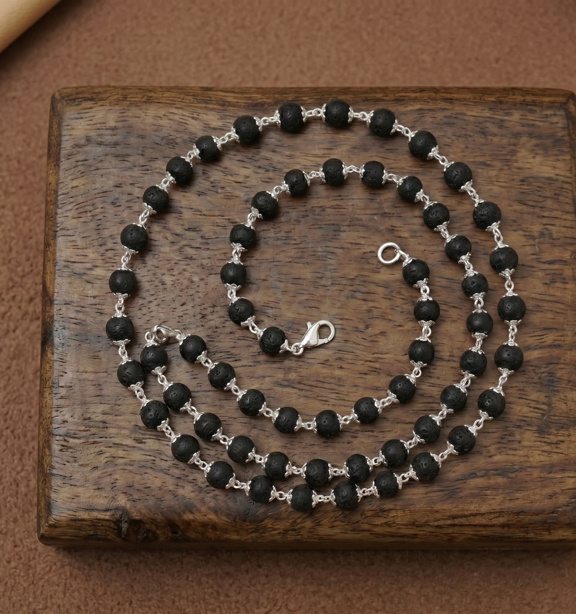 Karungali beads mala made in pure 925 sterling silver on a dark wooden surface