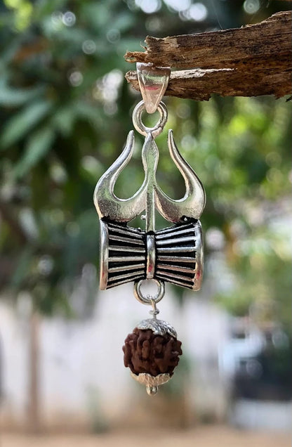 Close Image Trishul damru rudraksh pendant made in pure 925 sterling silver hanging on a wooden tree branch by silveristhan