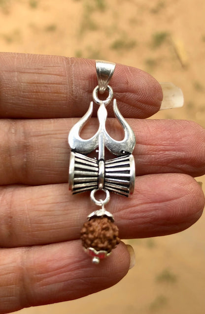 Close up image of a hand showcasing a trishul damru rudraksha pendant made in pure 925 sterling silver by silveristhan